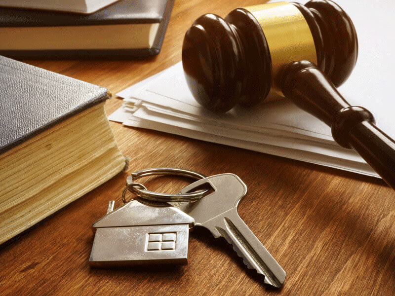 A gavel and some keys closeup on a table