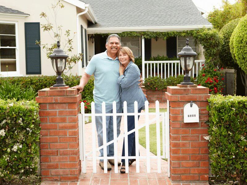 A happy family standing in front of their house