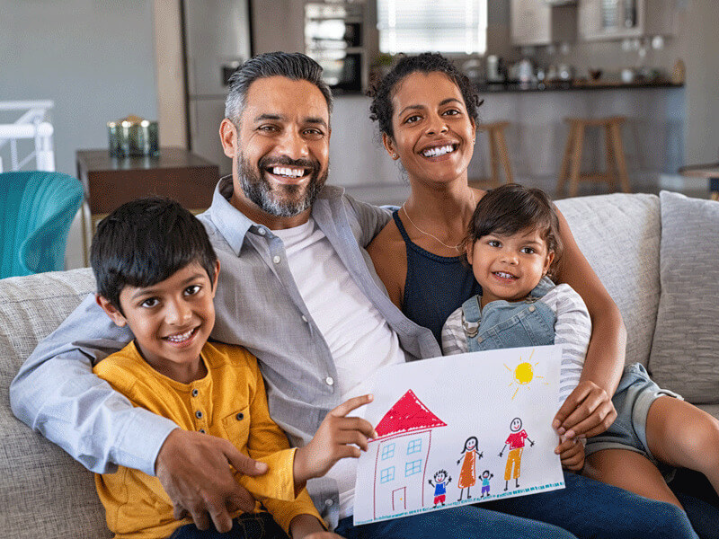 A big family posing with a picture drawn by a kid