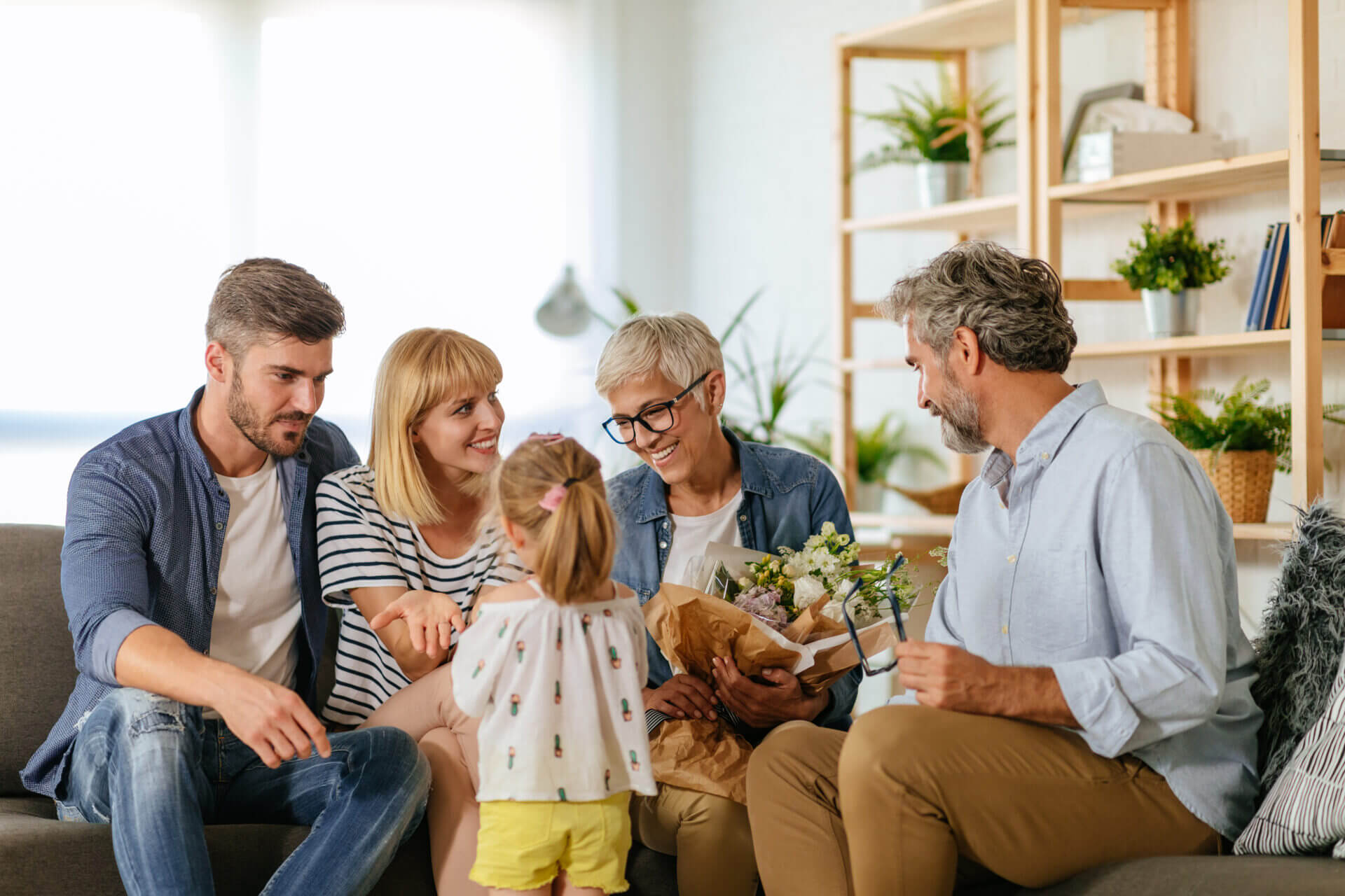 A family smiling with flowers.