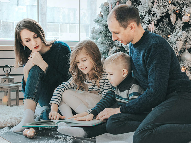 A family looking at a book together.