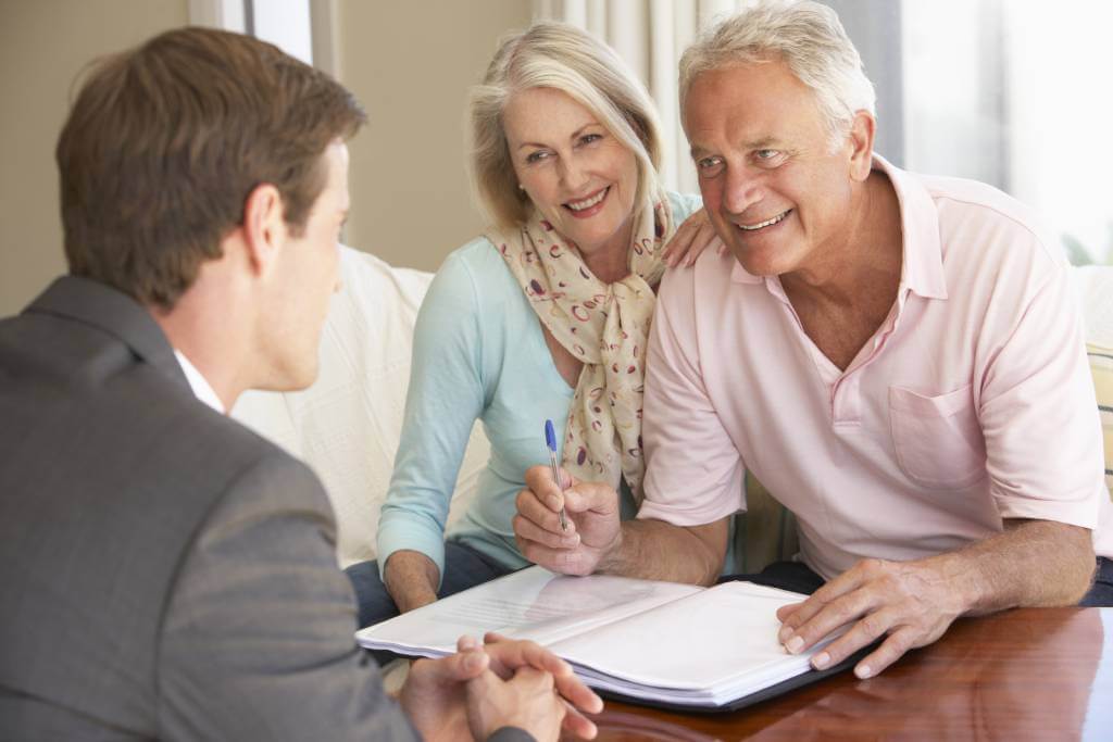 Sophisticated senior couple talking to male attorney about signing estate plan documents