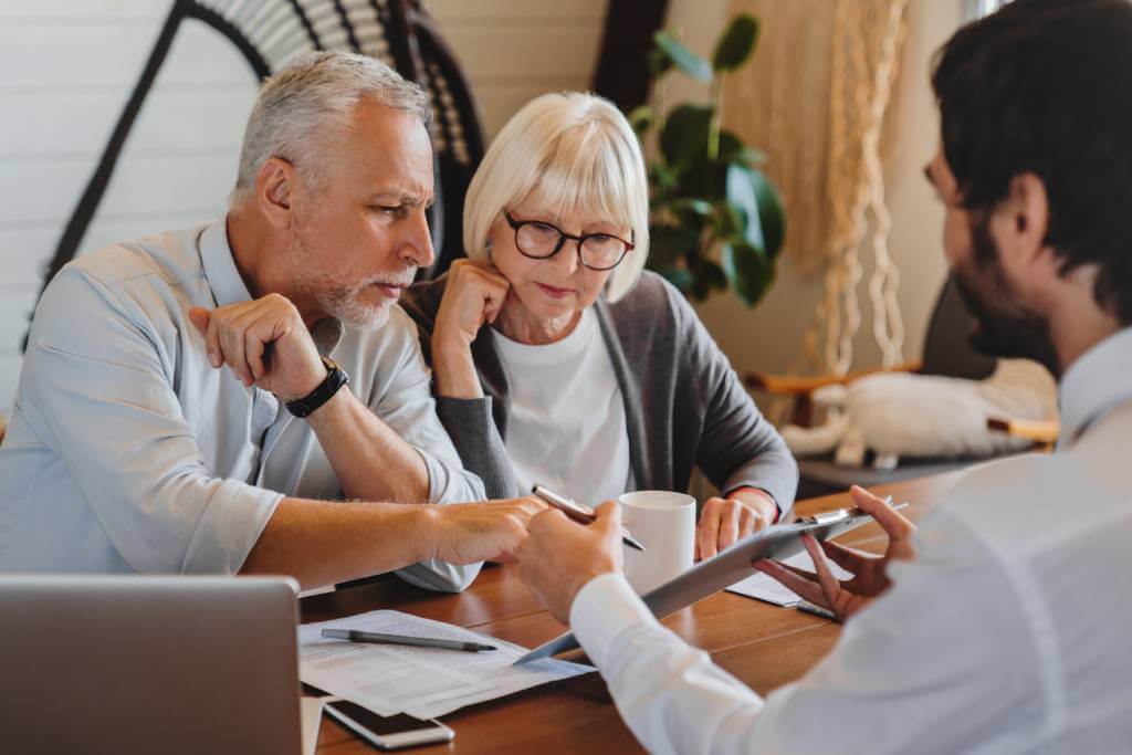 A senior couple looking at documents with a lawyer.