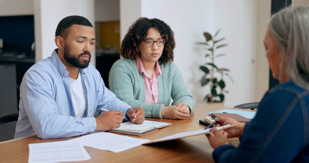 A Lawyer Showing Paperwork To A Couple