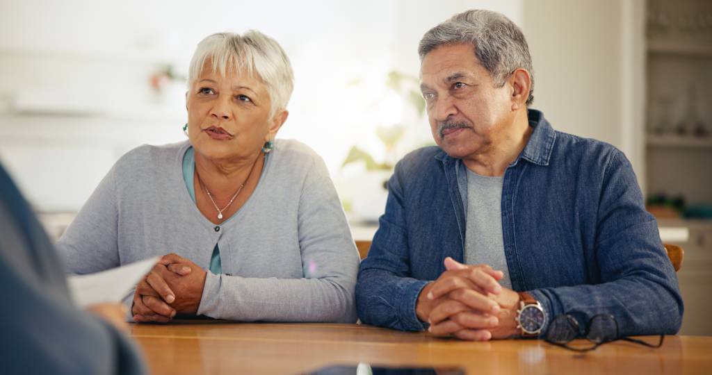 A senior couple meeting with an attorney.